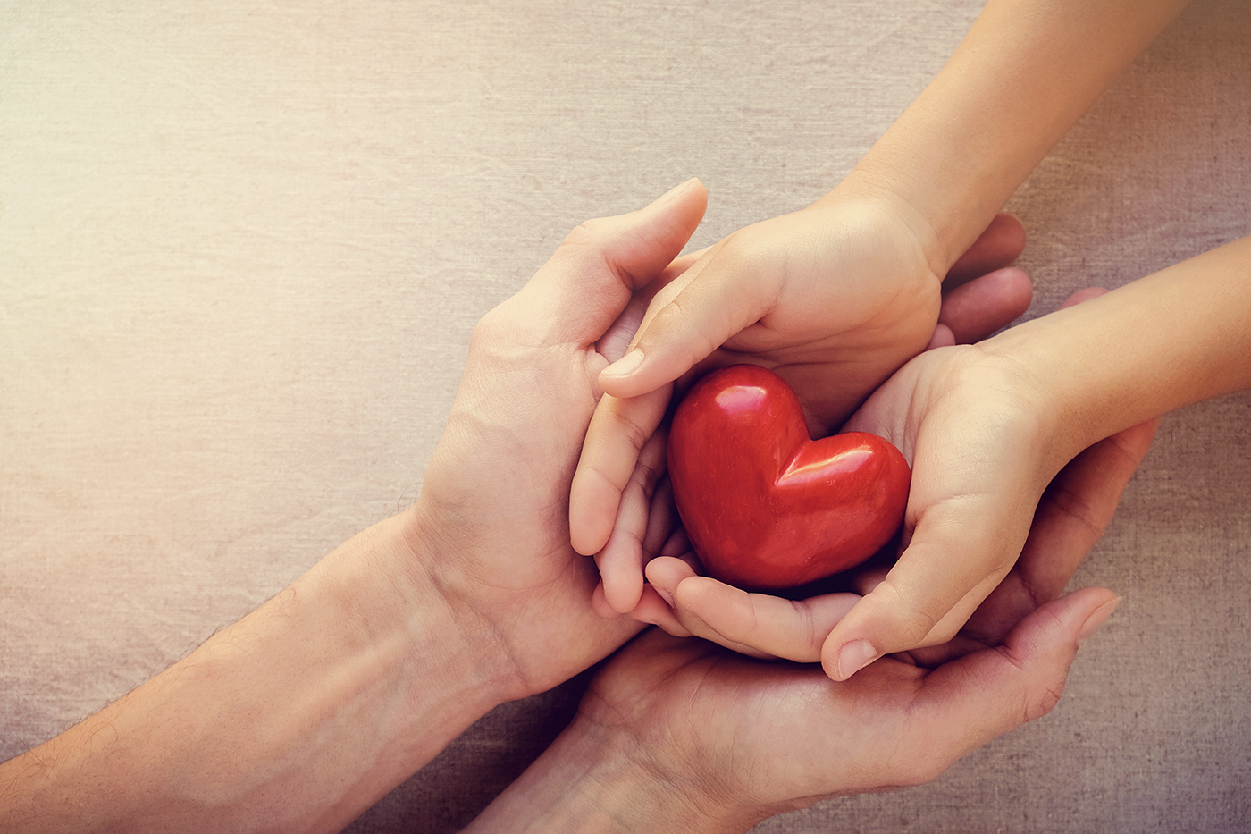 two people holding a heart in their hands to show love