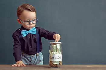 child putting money into a savings jar