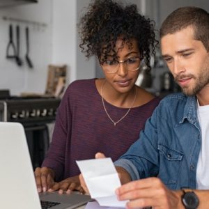interacial couple looking over receipts and statements using ukrfcu online banking money mangement