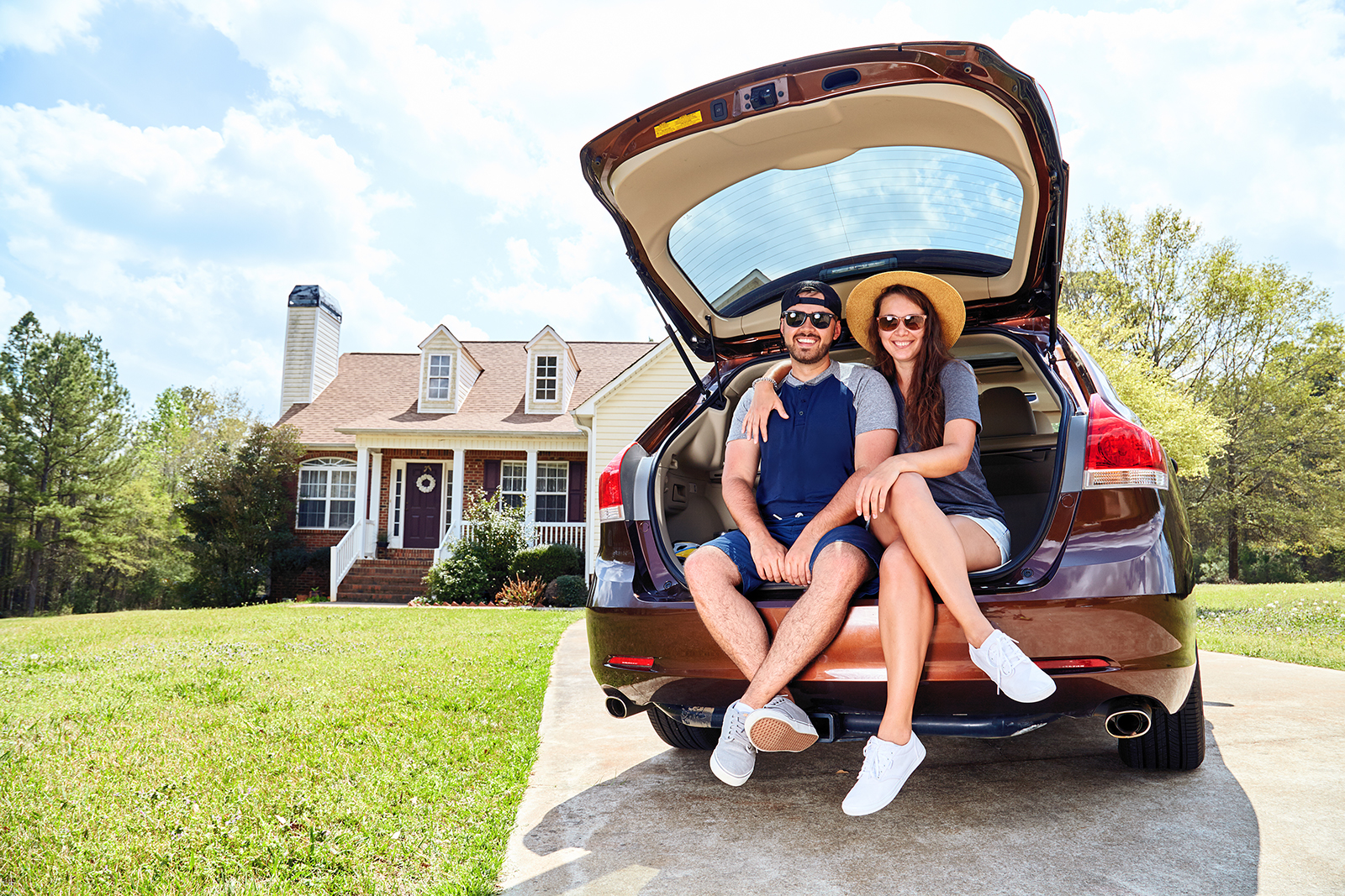Family in the back of their car infront of their home