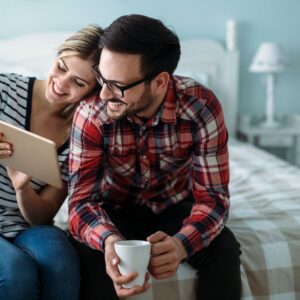 happy couple looking at a tablet together at home