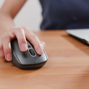 person using laptop with hand on the mouse