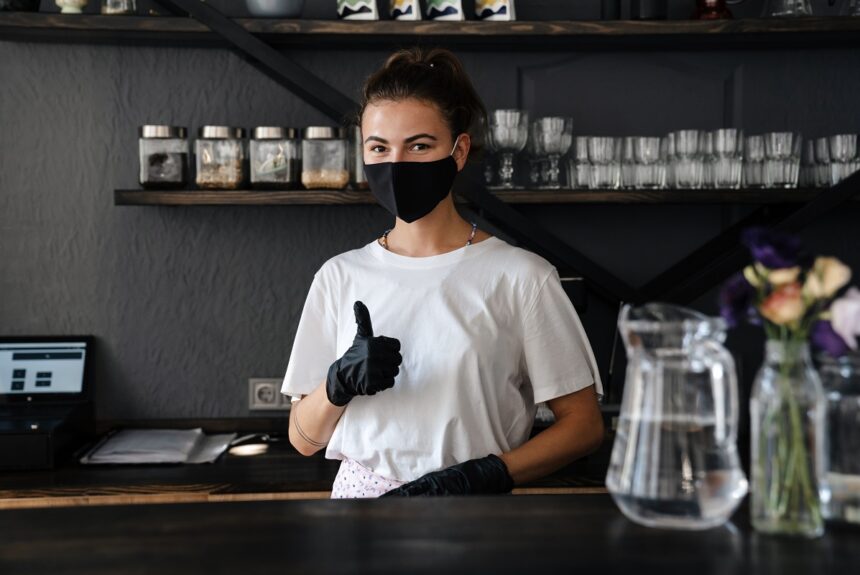 Business owner and barista wearing face mask