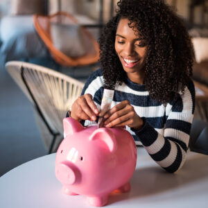 individual placing money into a piggy bank