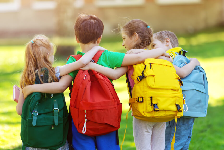 Group of children with rucksacks standing in the park near the school Smart Ways to Save on Back to School Shopping with UKRFCU